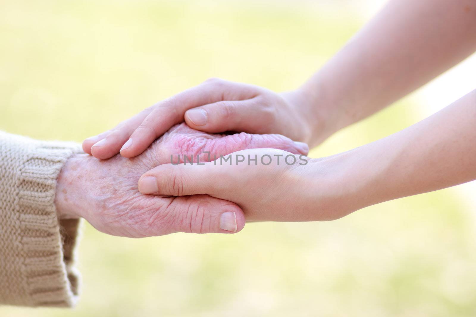 Senior lady and young women holding hands 