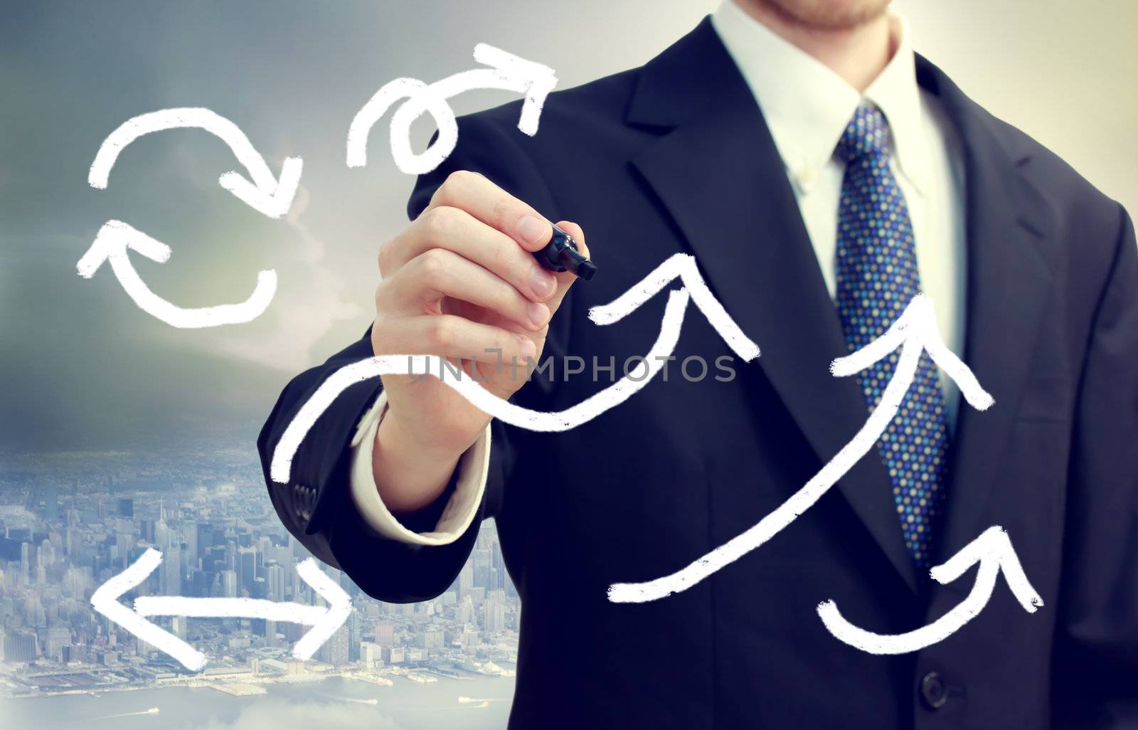 Business man drawing arrows with city background