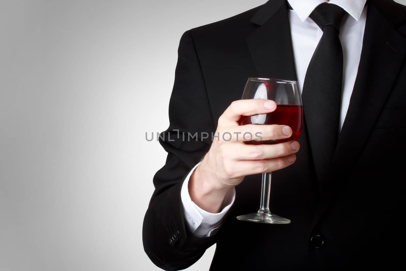 Young man holding a glass of red wine  by melpomene