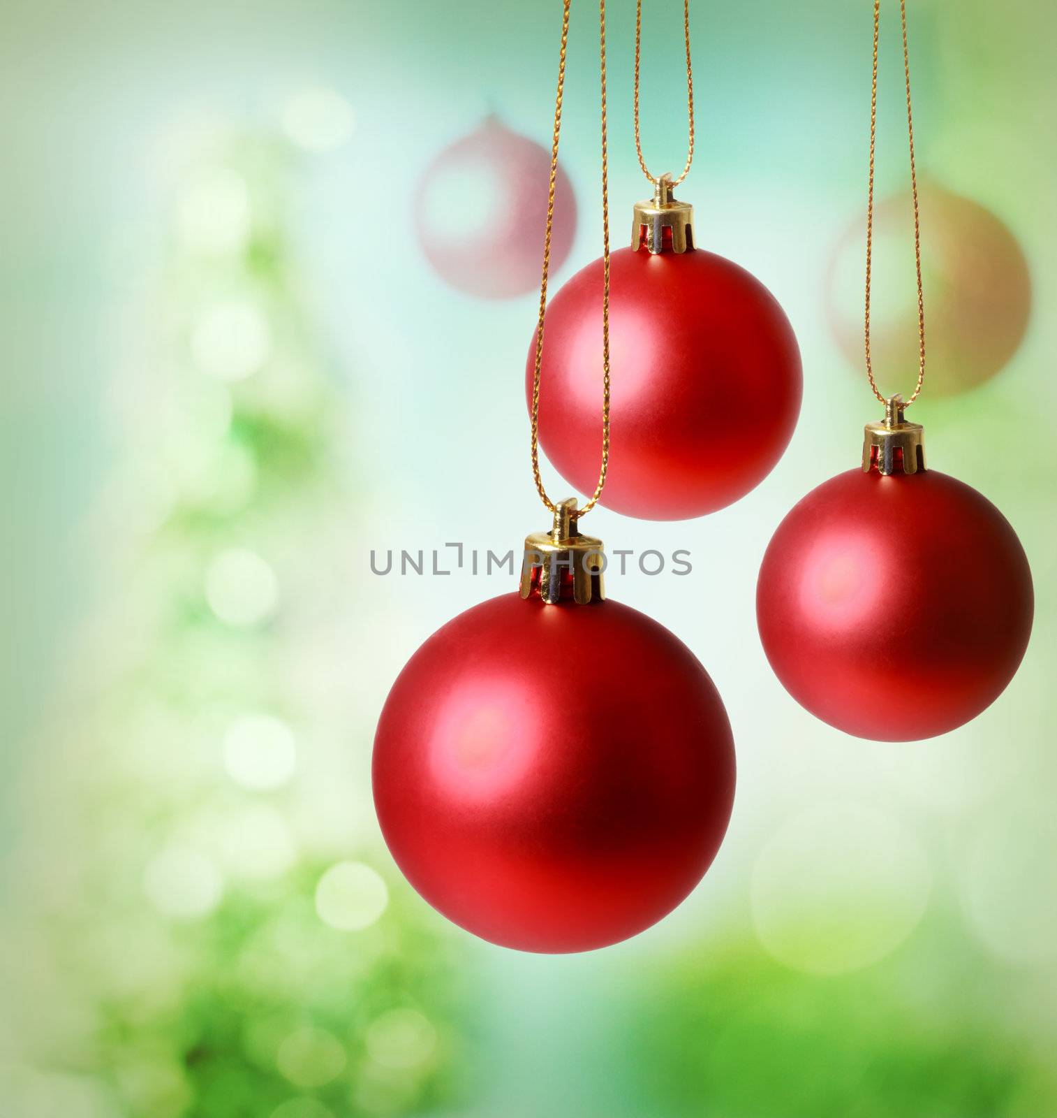 Christmas red ornaments over green tree lights background