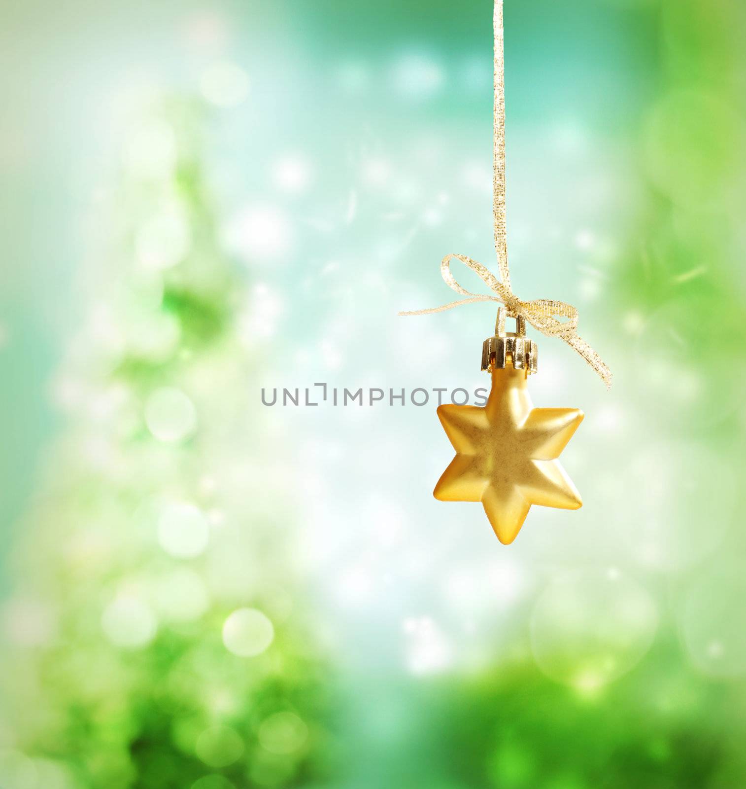 Christmas star ornament over green tree lights background
