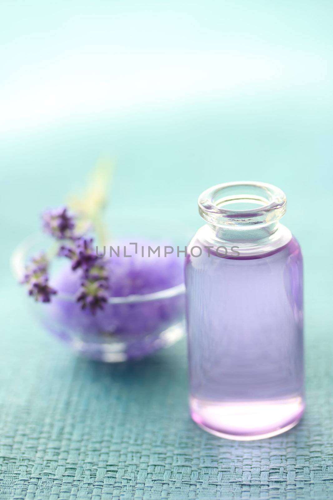 Aromatherapy oil and lavender with bath salt over blue background