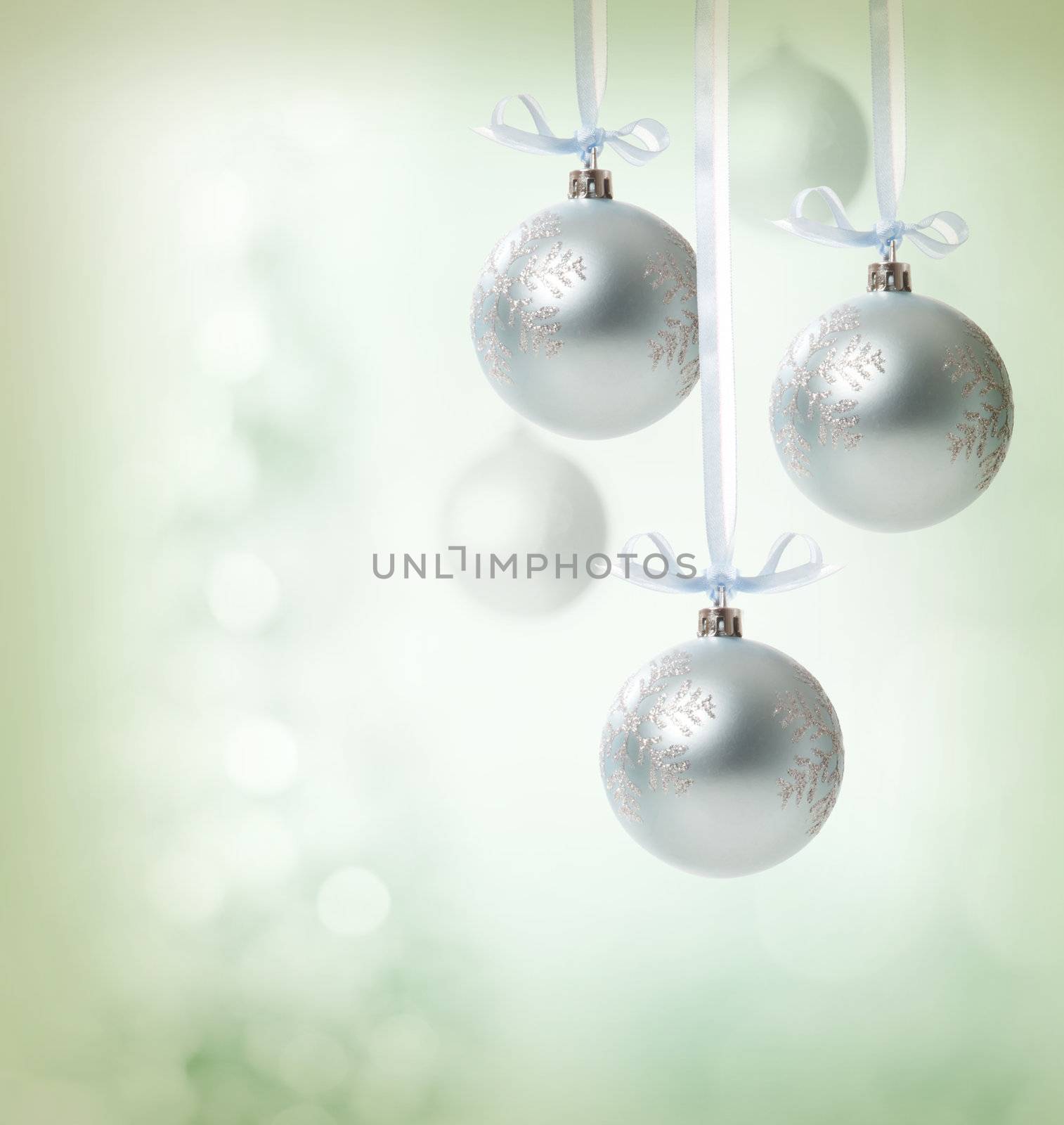 Christmas snowflake ornaments over soft green lights background