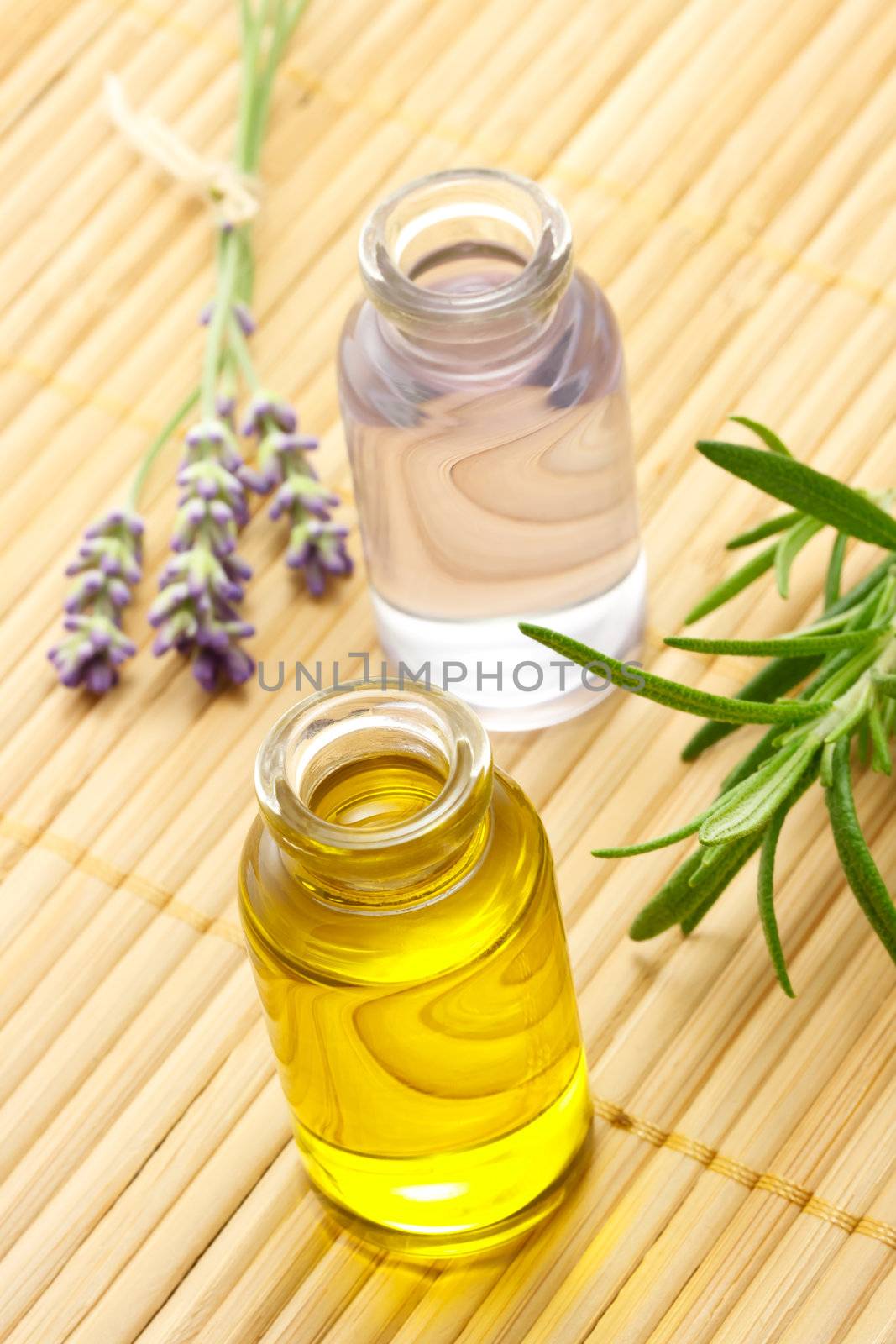 Aroma oil in bottles with lavender and rosemary