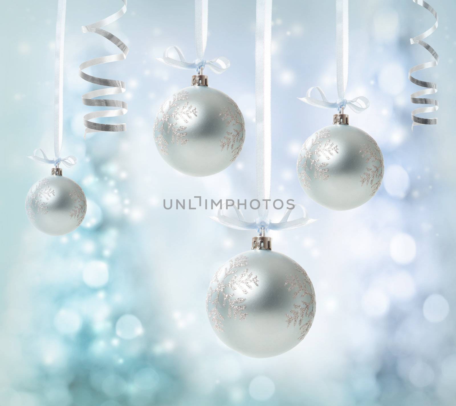 Silver Christmas Ornaments over glowing tree background