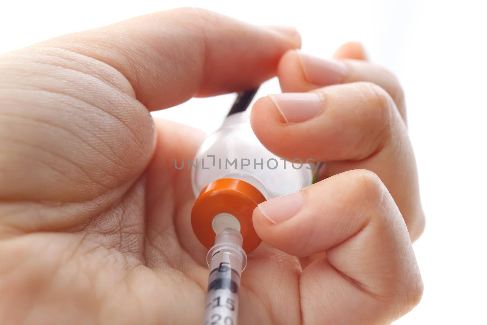 Hand holding syringe and vial on white background