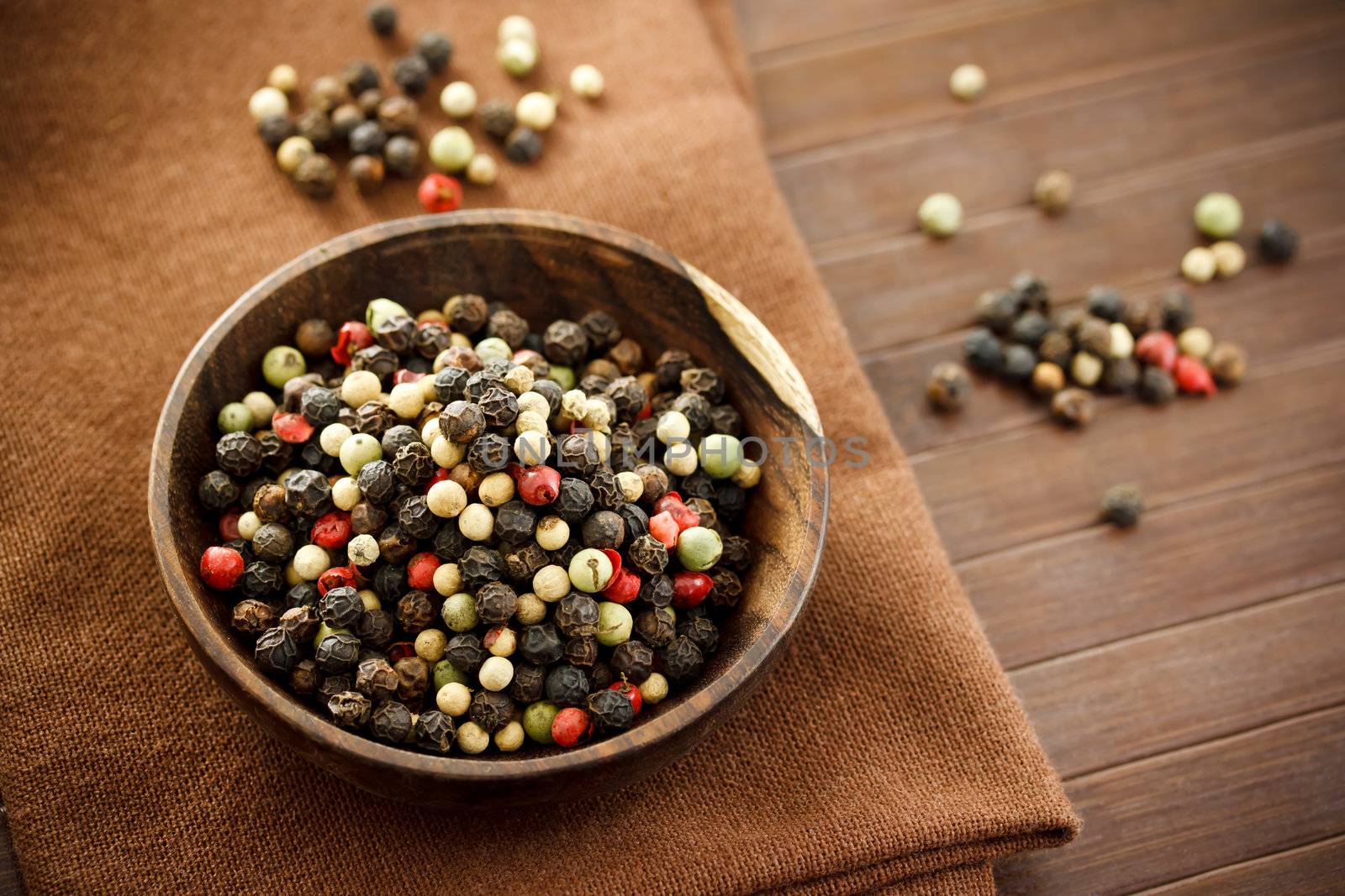 Colorful rainbow peppercorns in wooden bowl