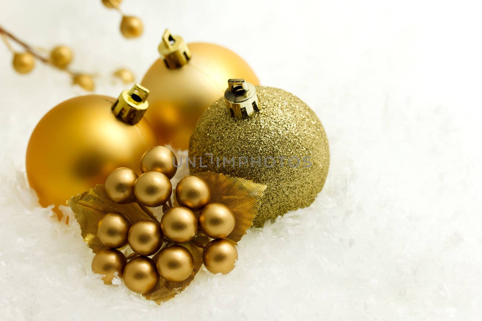 Gold christmas baubles and ornaments on white snow