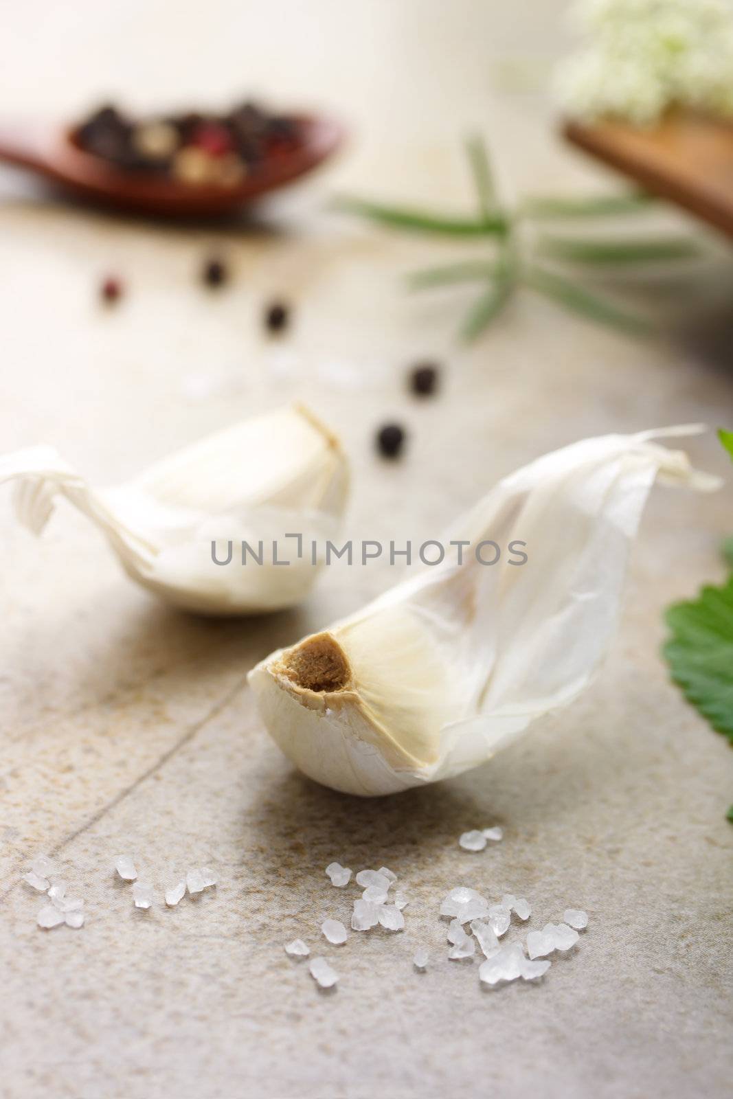 Garlic cloves with peppercorn, salt, rosemary and mint