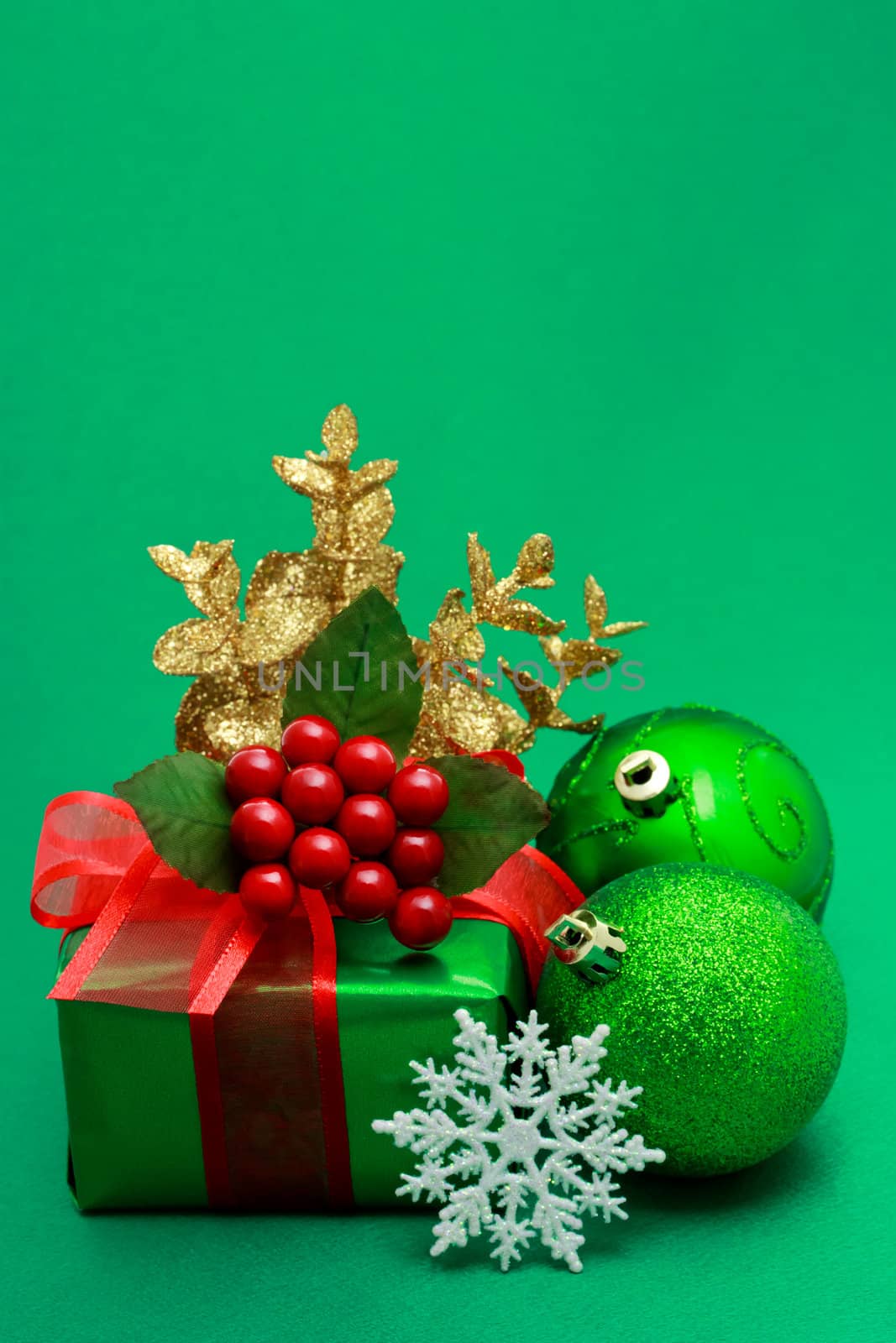 Christmas green gift box with ornaments on green background