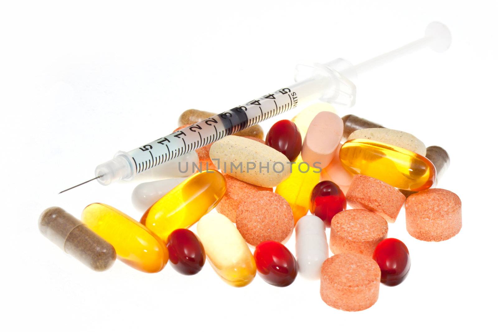 Syringe with supplements on white background