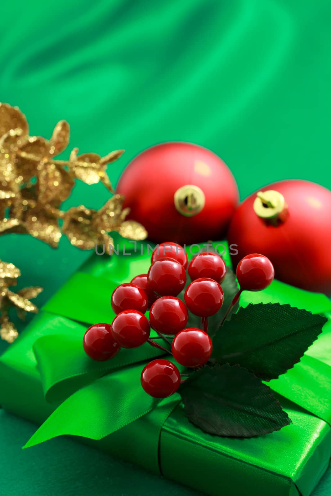 Christmas green gift box with ornaments on green silky background