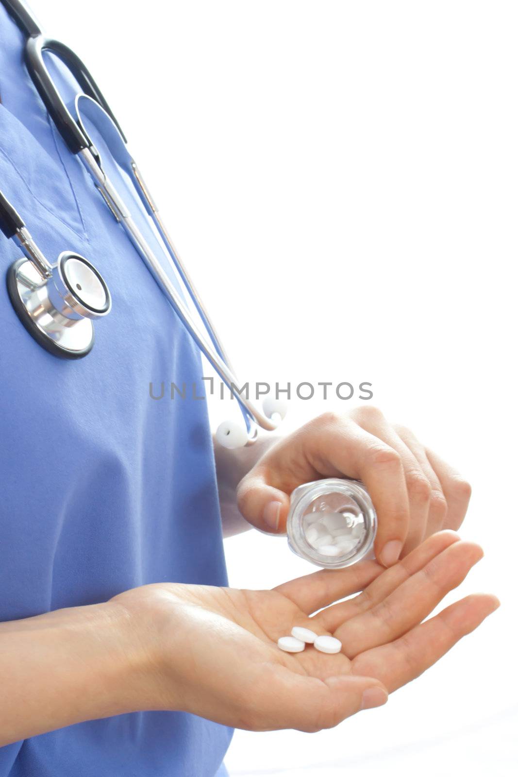 Doctor holding pills over white background