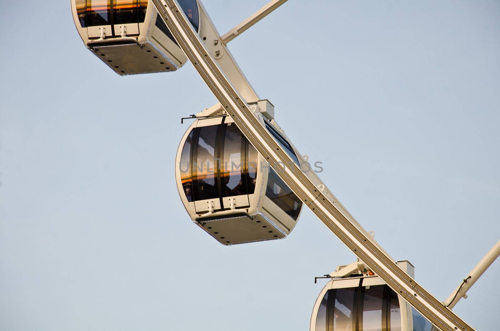 White ferris wheel at sunset with reflection in the mirror.