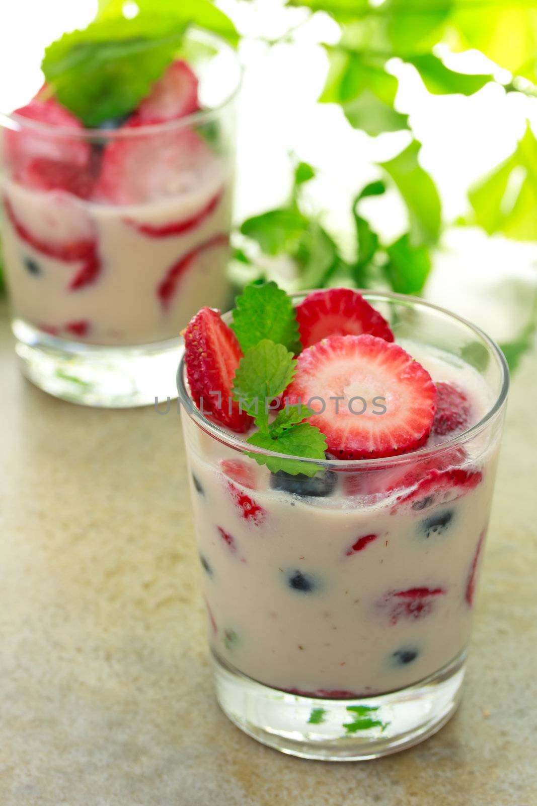 Vanilla yogurt with strawberries, blueberries and lemon balm