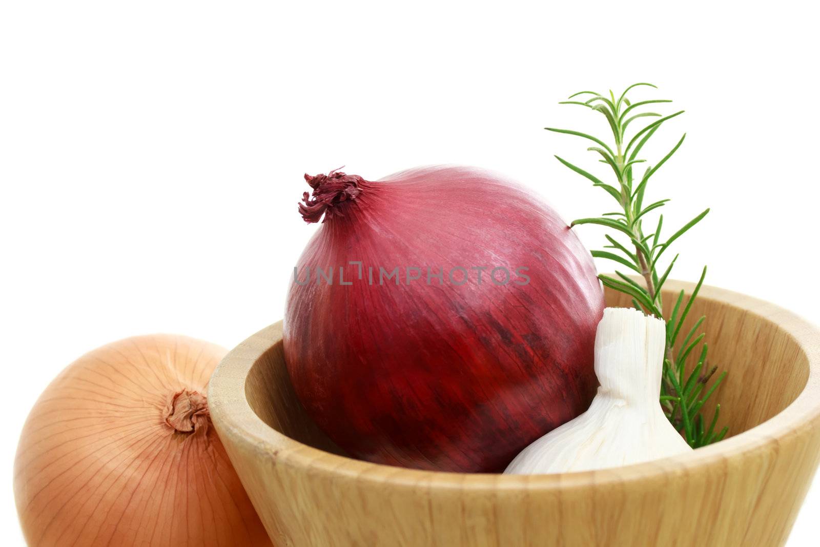 Onions and garlic in wooden bowl over white background