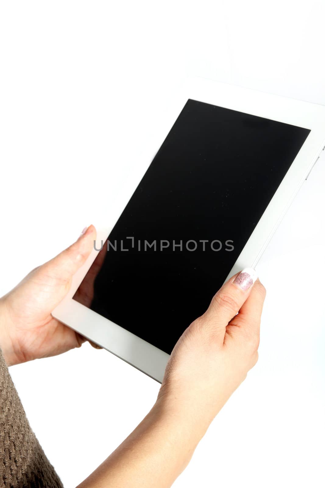 Cropped view isolated image on white of female hands holding a touchscreen tablet with a blank screen angled towards the camera