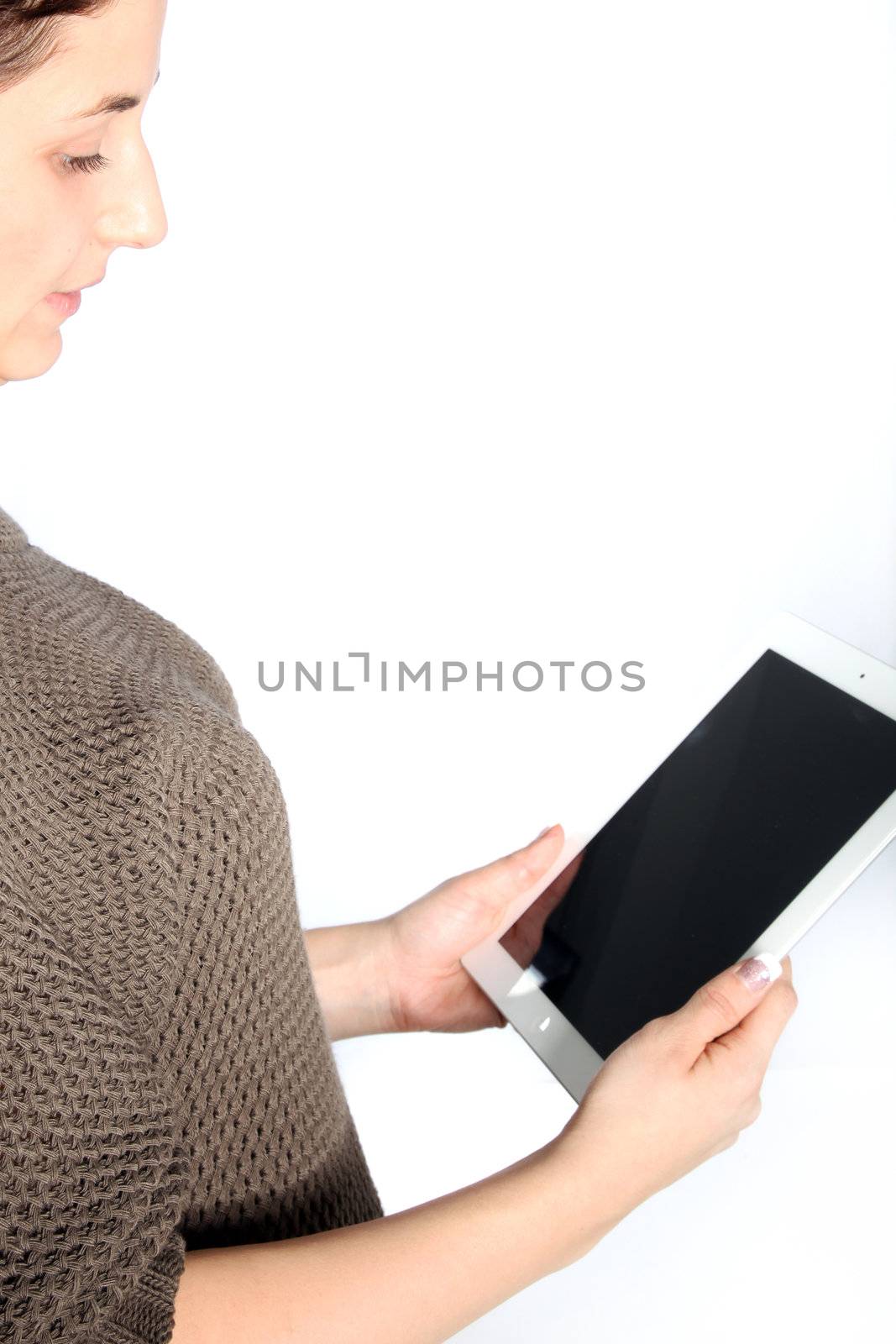 Cropped partial view of an attractive woman reading a tablet with a blank screen angled towards the camera isolated on white