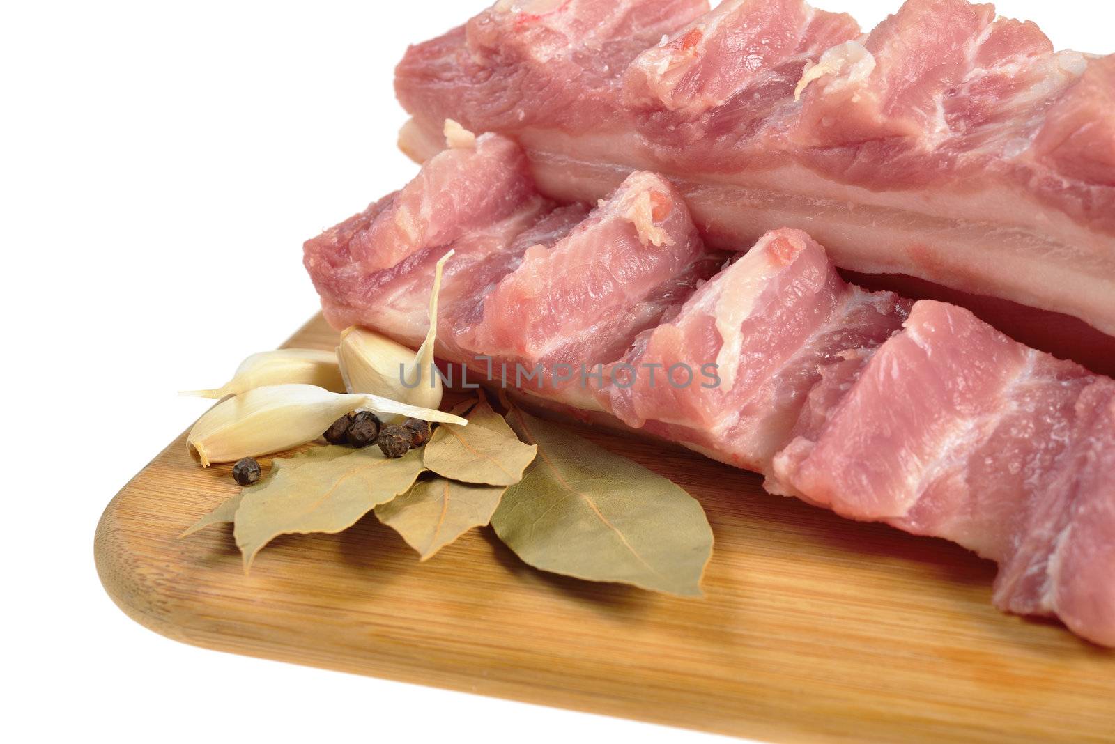 Raw bacon with ribs on a wooden cutting board. Isolated on white.