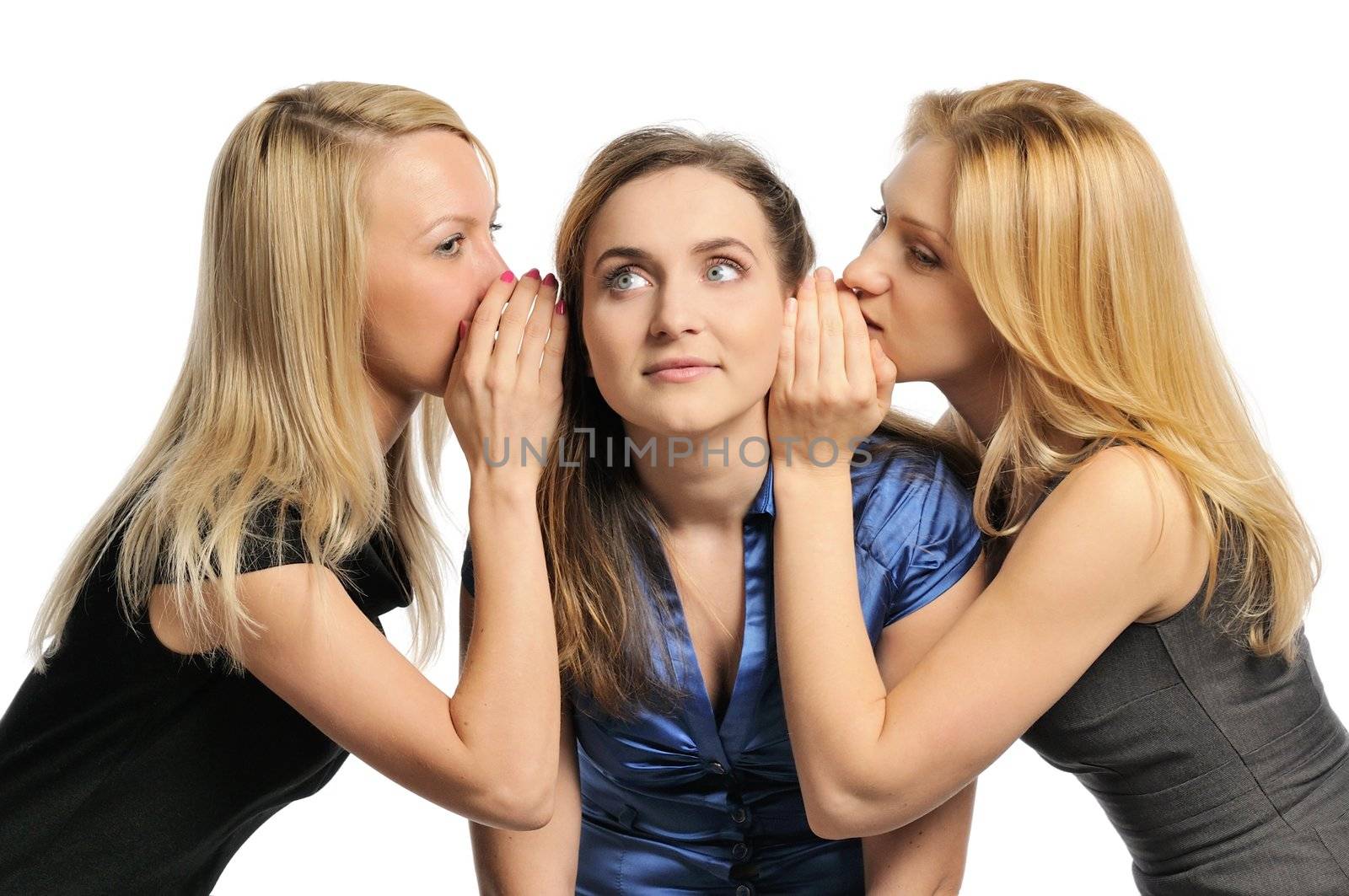 Three young girls gossiping, whispering to each other's ears. Isolated on white.