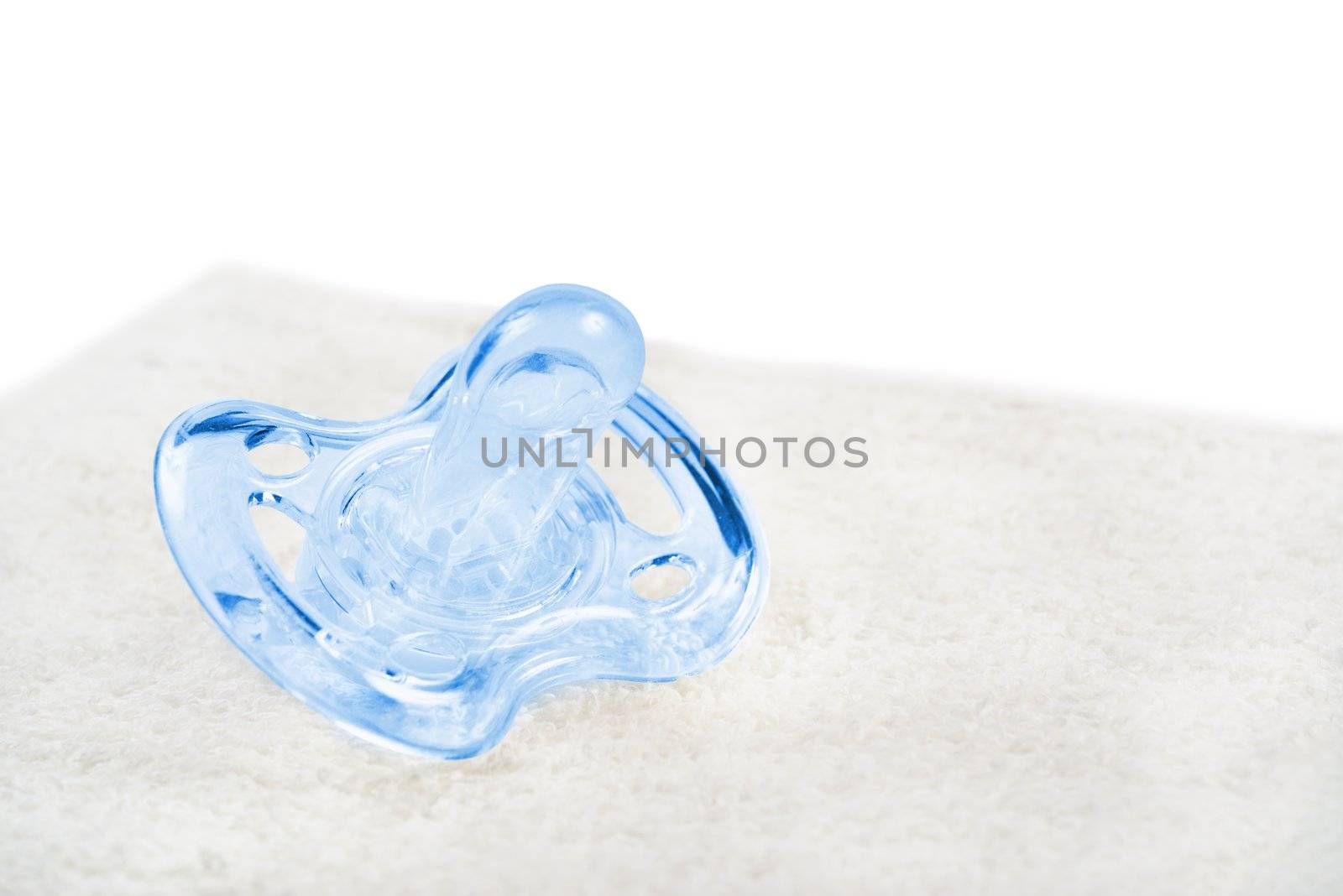 Baby pacifier on towel. Isolated on white.