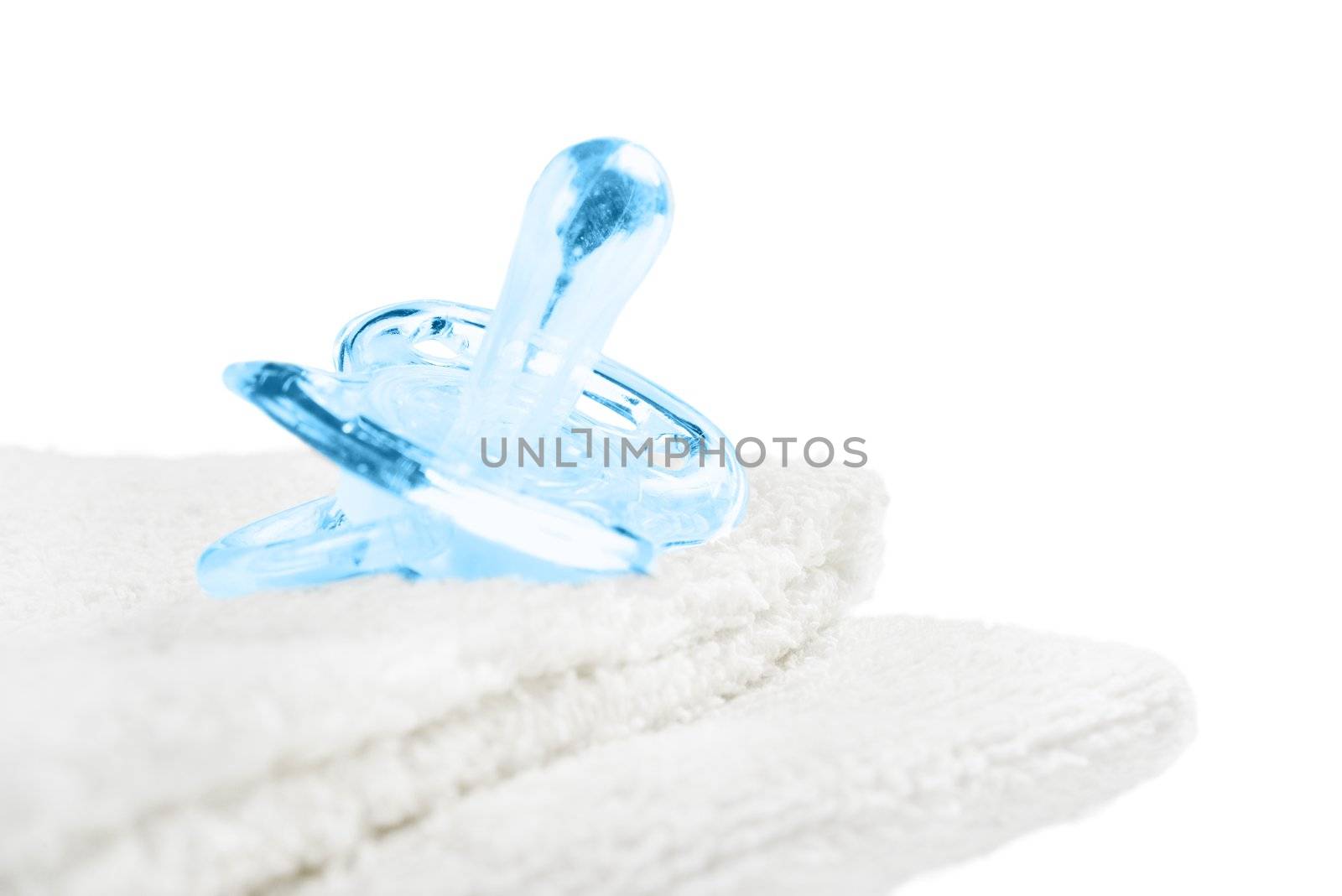 Baby pacifier on towel. Isolated on white.