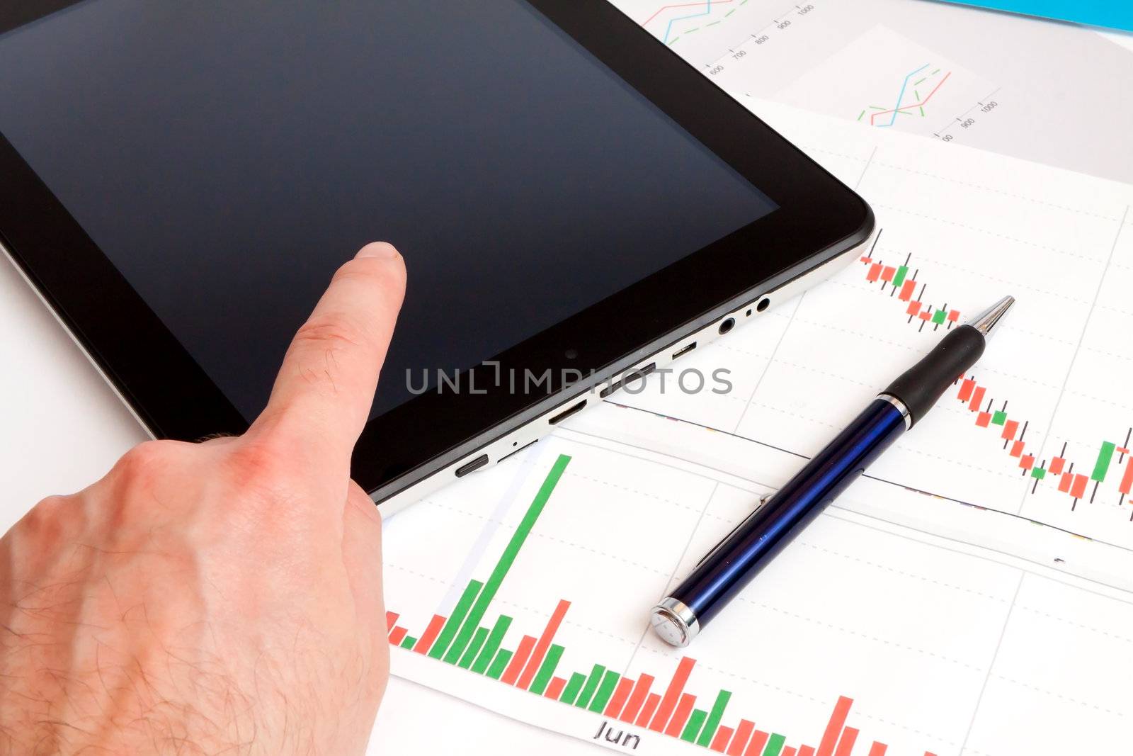 Desktop in stock exchange office with a tablet pc showing stock market chart. 