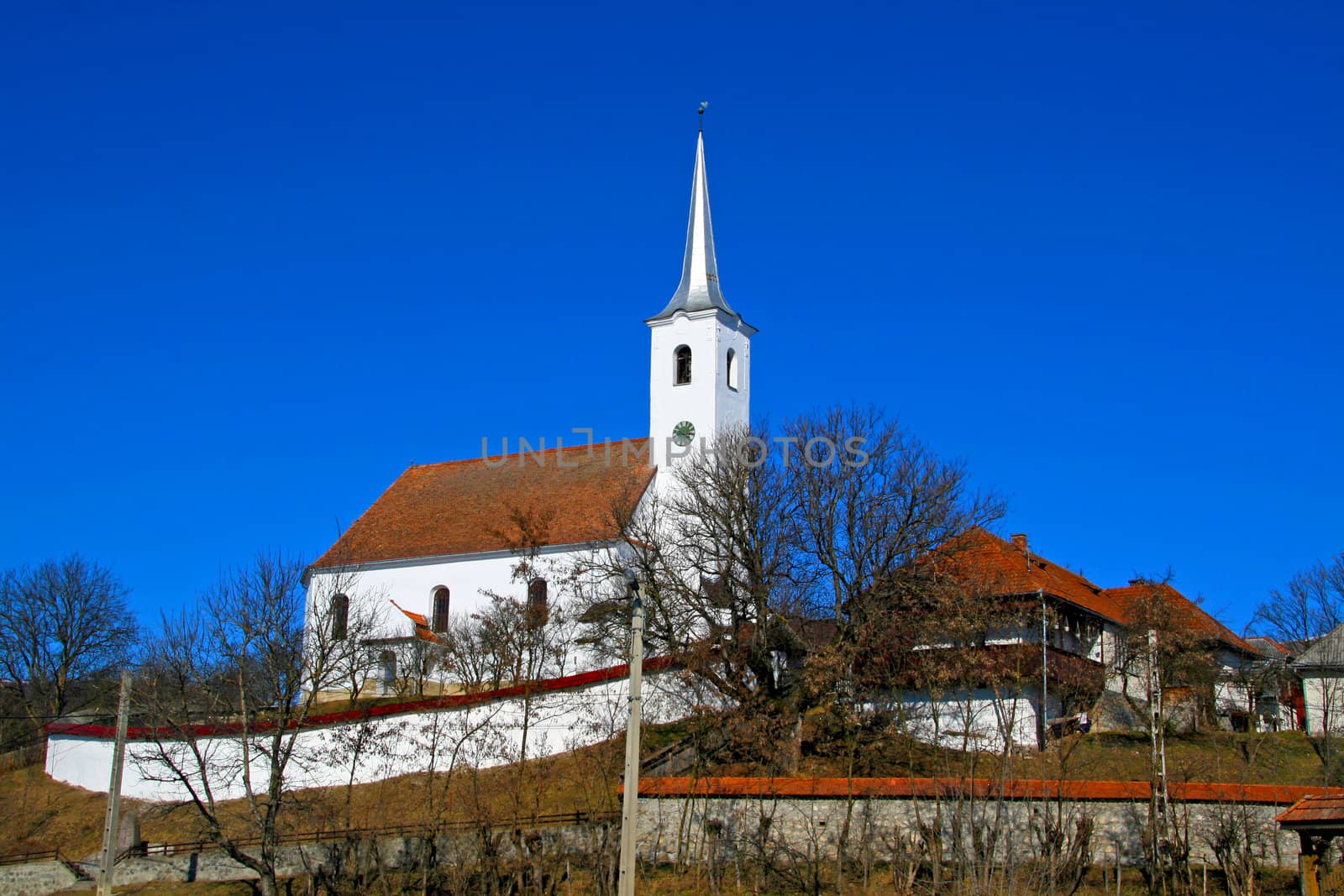 White church and spire with walls for defence