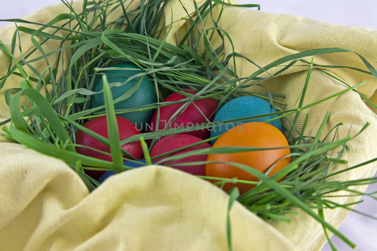 Colorful easter eggs in a basket and grass nest