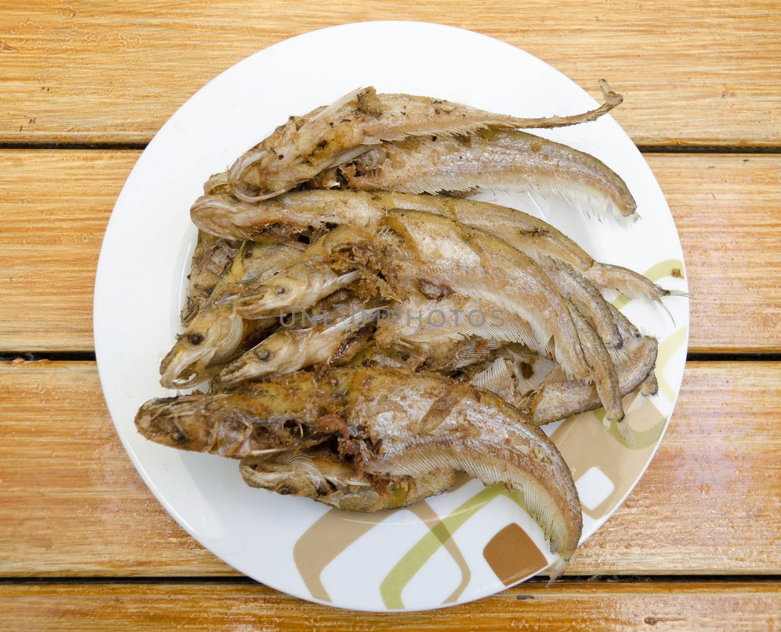 Fried fishes on dish by siraanamwong