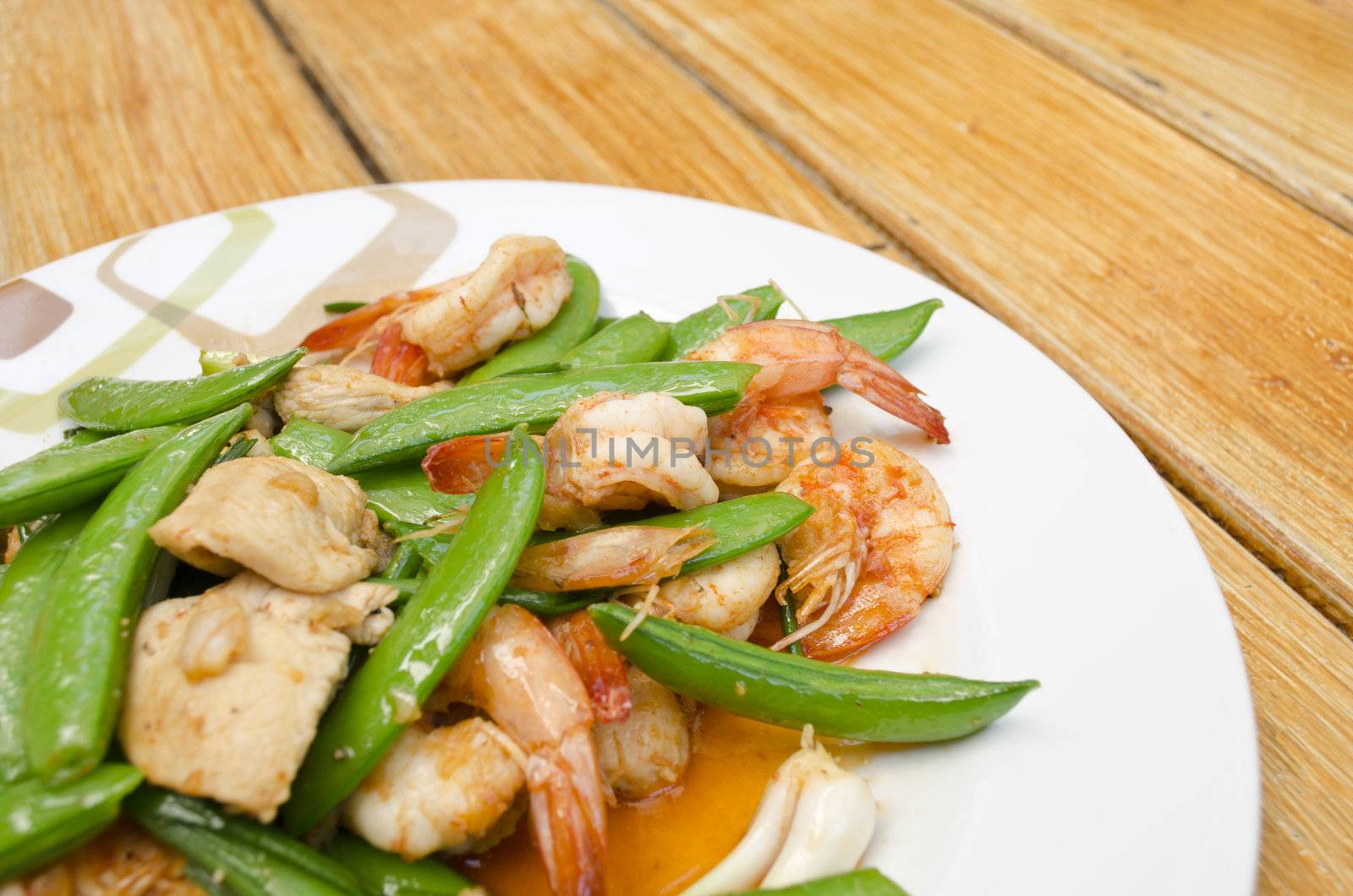 Thai-food Fried shrimp, pork and sweet peas. wood background.