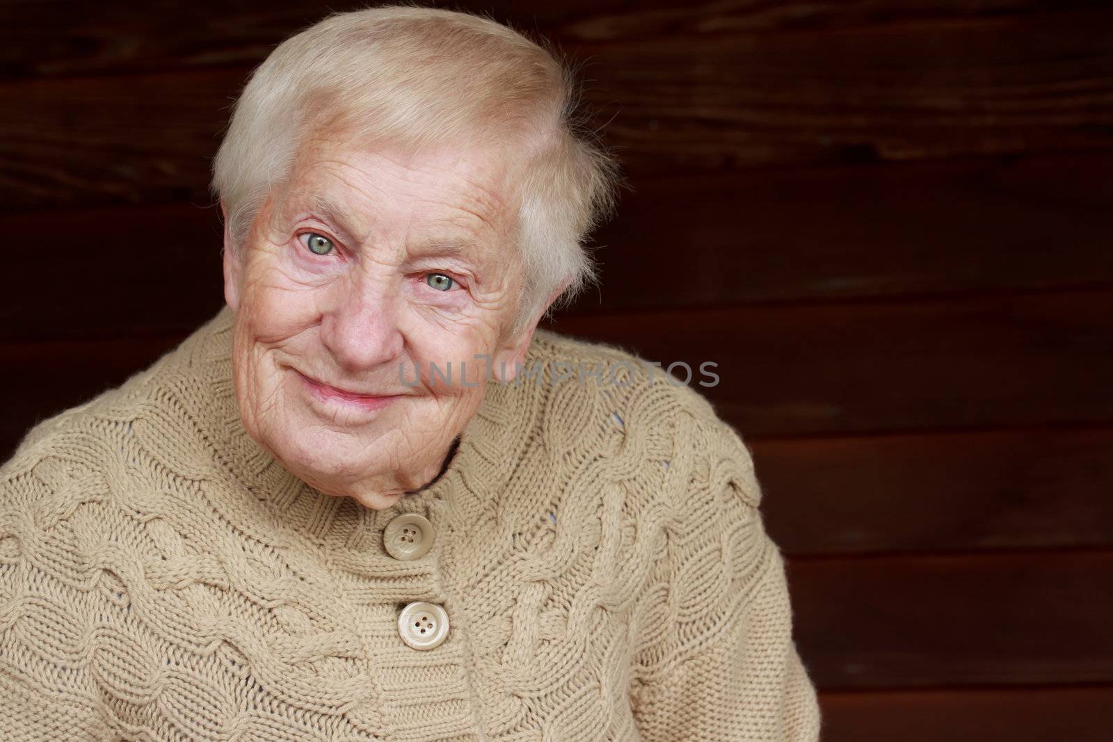 Happy senior lady in beige sweater smiling 
