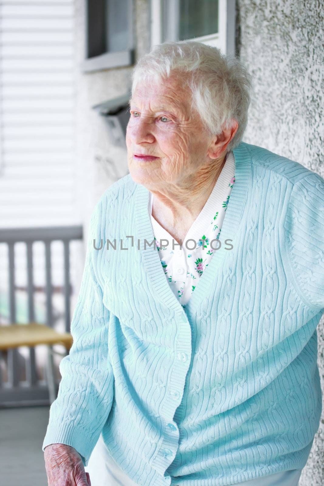 Senior lady standing on the porch