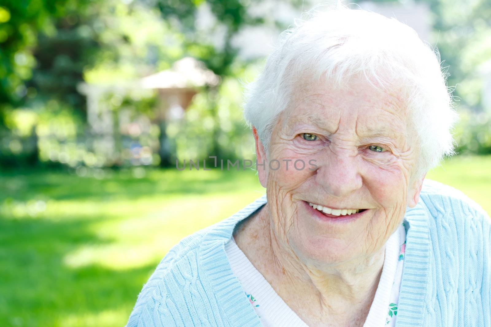 Happy senior lady smiling in spring garden