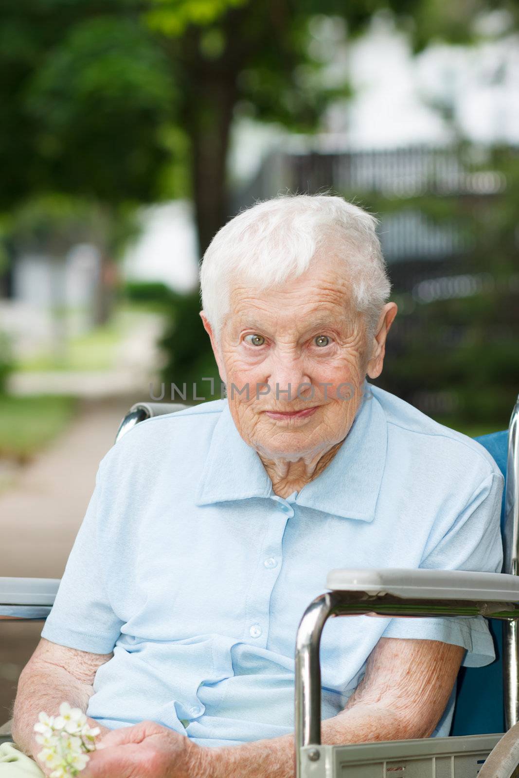 Happy senior lady in wheelchair smiling outside