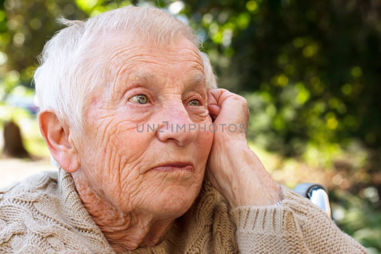 Pensive senior lady in wheelchair outside