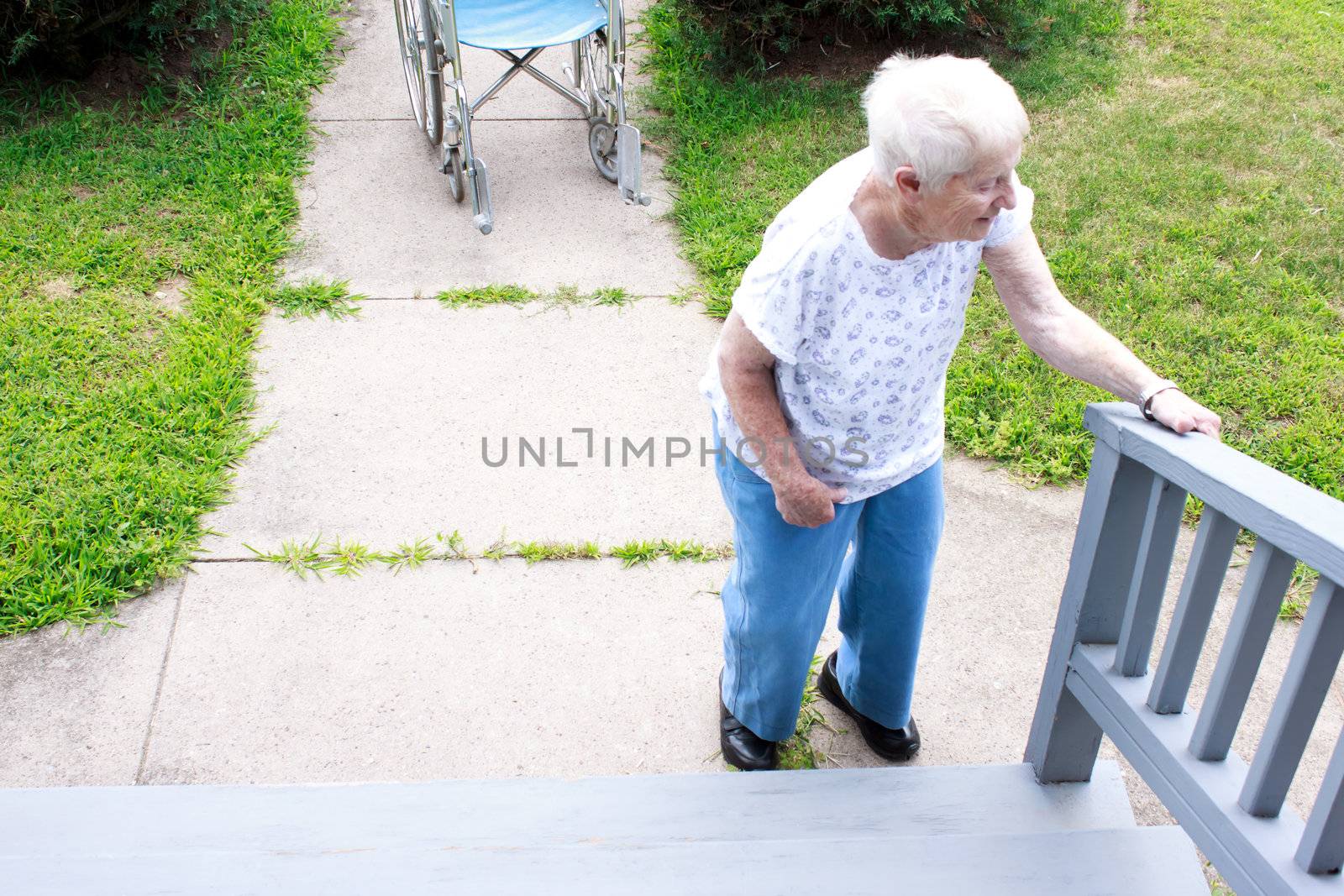 Senior lady standing in front of staircase and holding railing