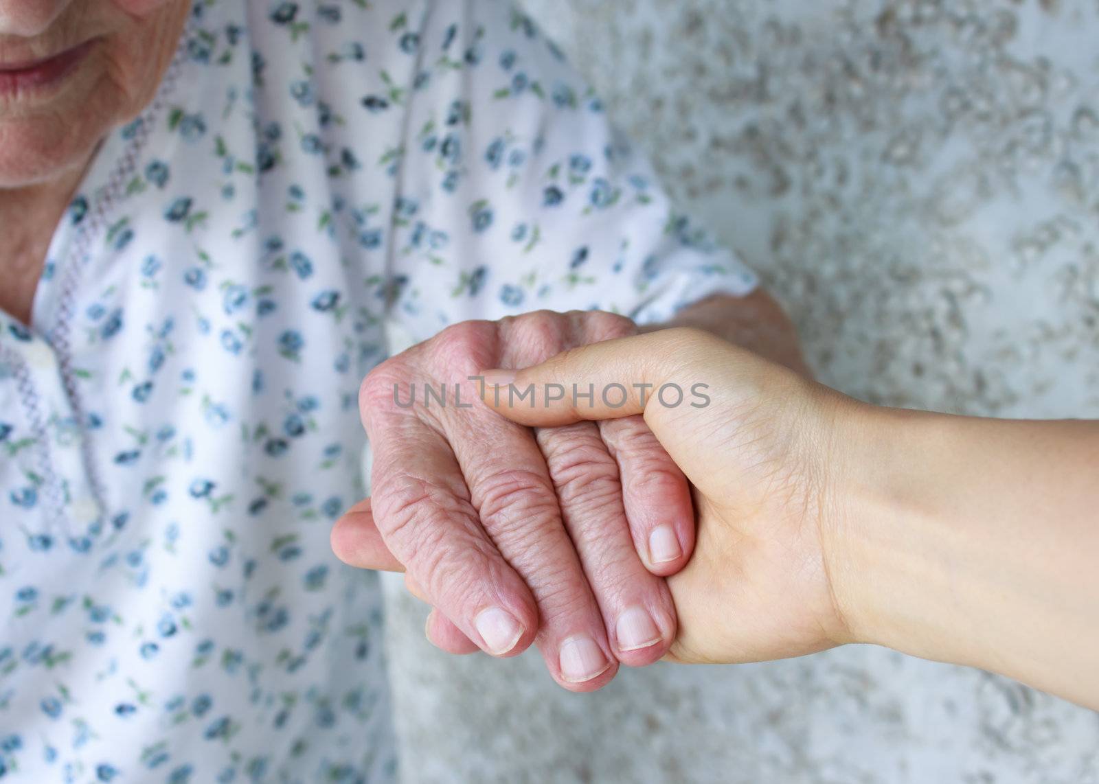 Young holding senior lady's hand