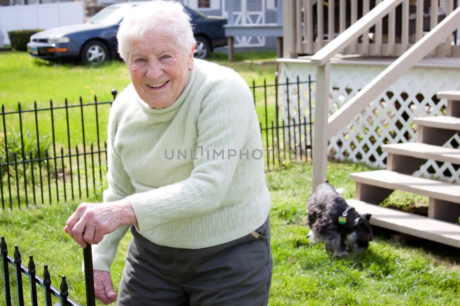 Happy senior lady in backyard with her dog
