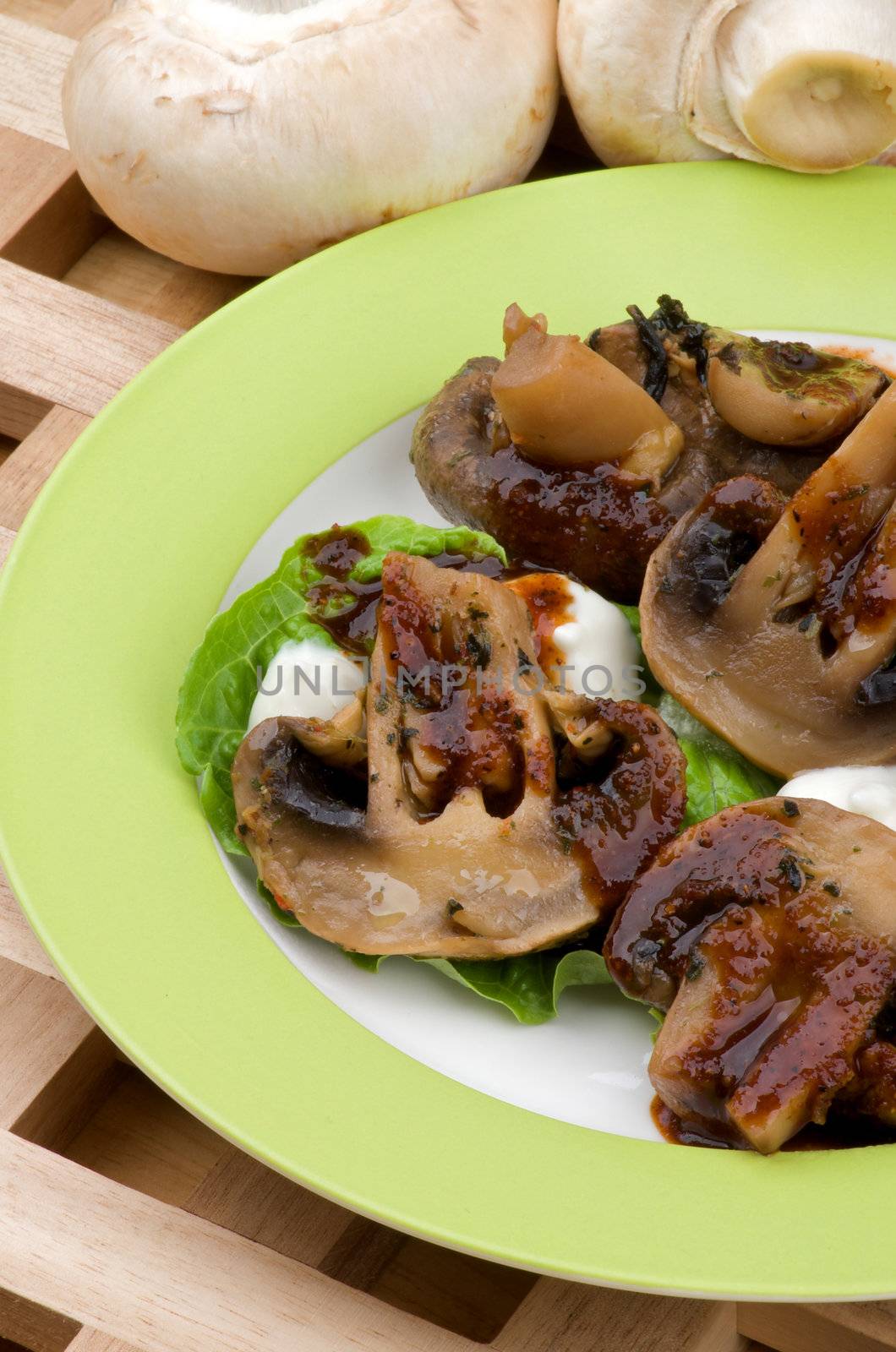 Cooked Mushrooms with Grill Sauce, Sour Cream and Greens on Plate closeup on Wood background and Raw Mushrooms 