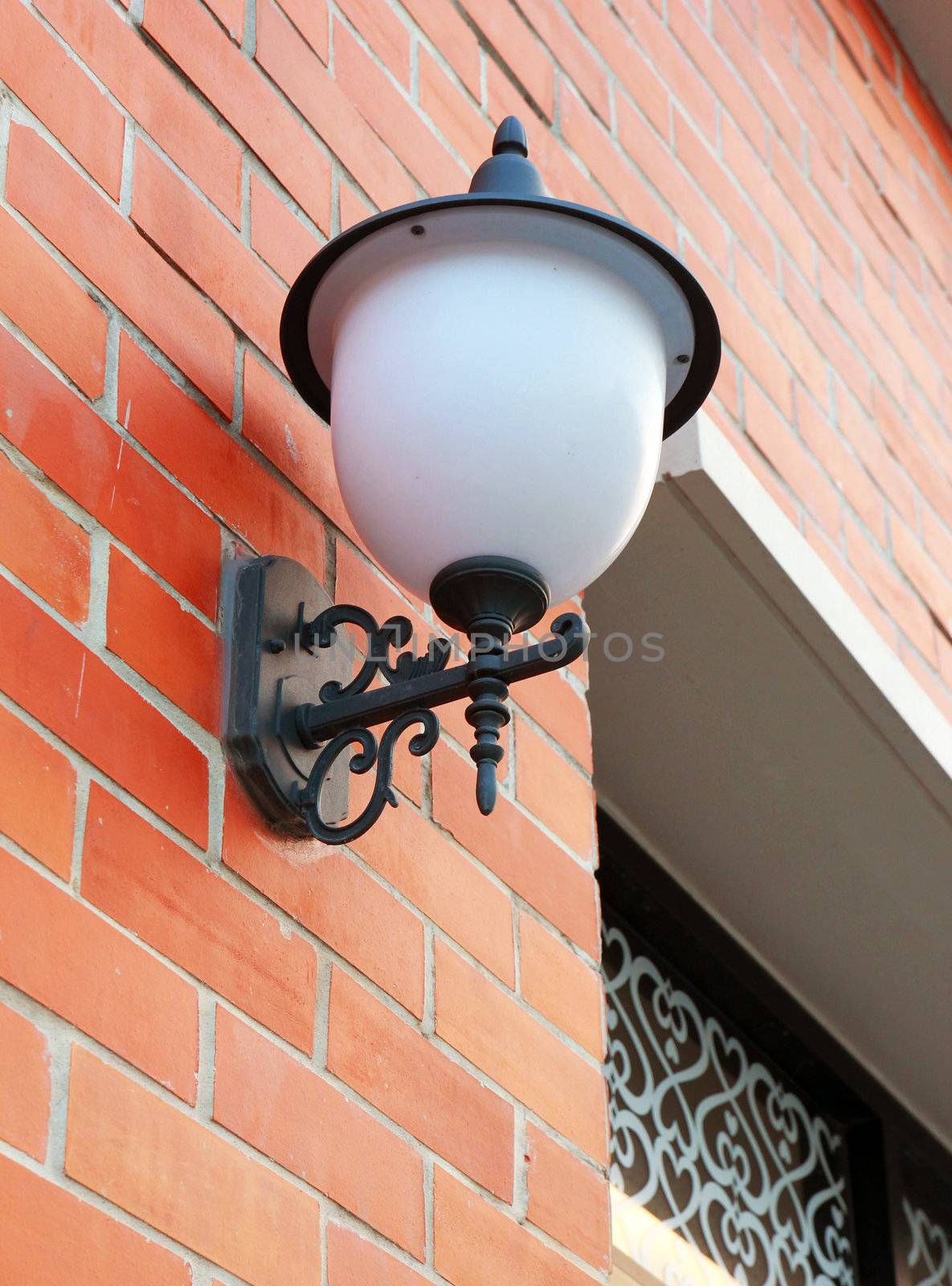 Street lamp on a textured brick wall 