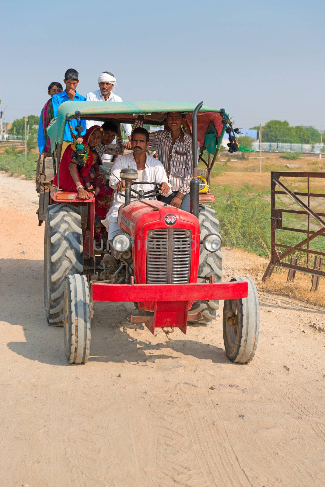 Sambhar, India - Nov 19: Country people travel by tractor on country road on Nov 19, 2012 in Sambhar Salt Lake, India. Villages near Sambhar Salt Lake produce 196 k tonnes of clean salt every year.