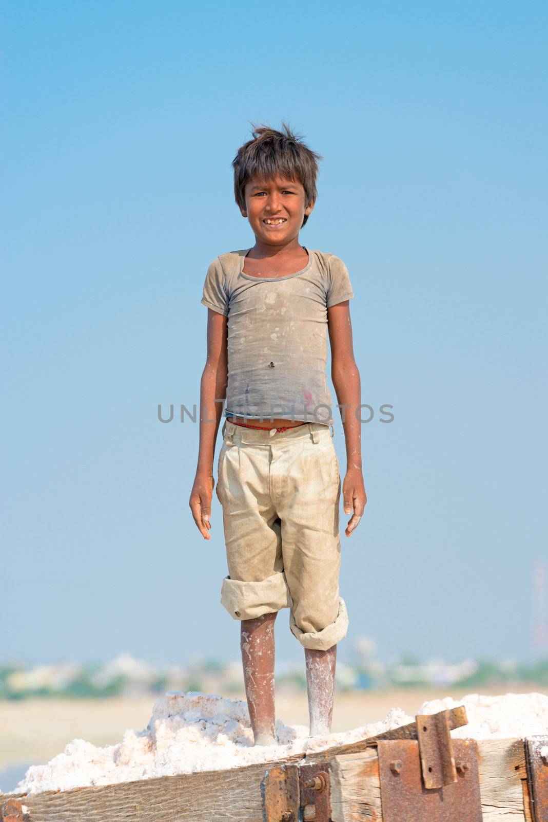 Sambhar, India - Nov 19: Portrait of indian kid in salt farm on Nov 19, 2012 in Sambhar Salt Lake, India. It is India's largest saline lake and where salt has been farmed for a thousand years. 