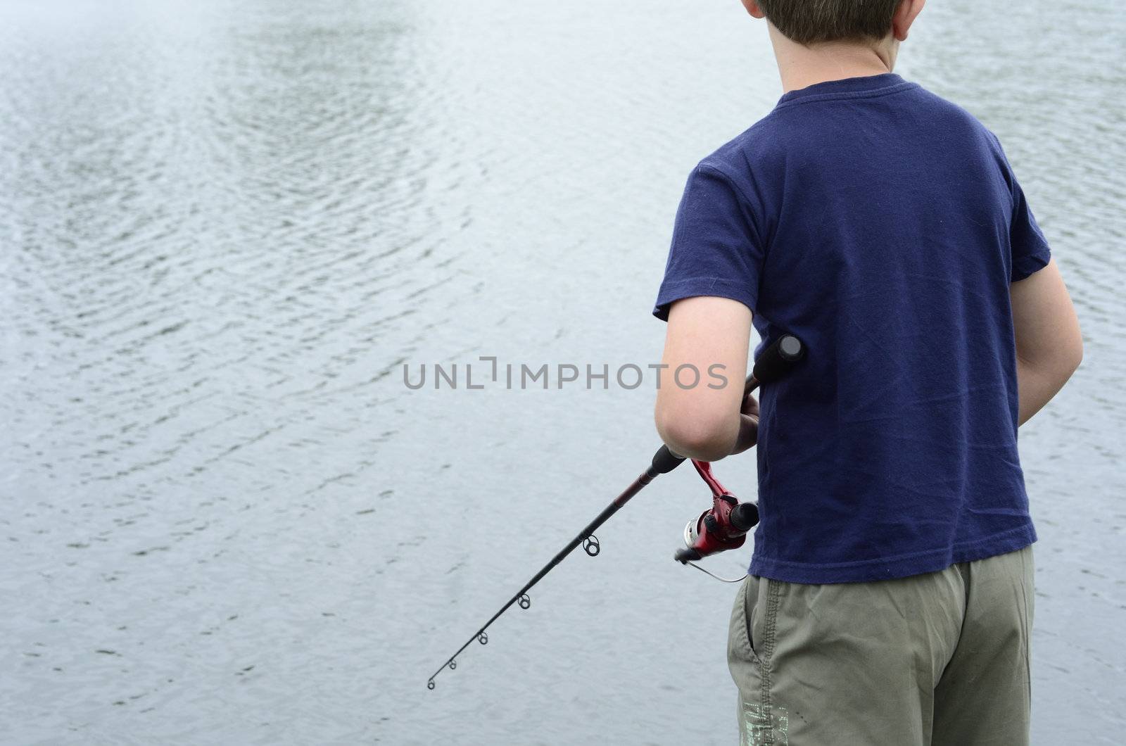 Boy fishing in bass dam or lake