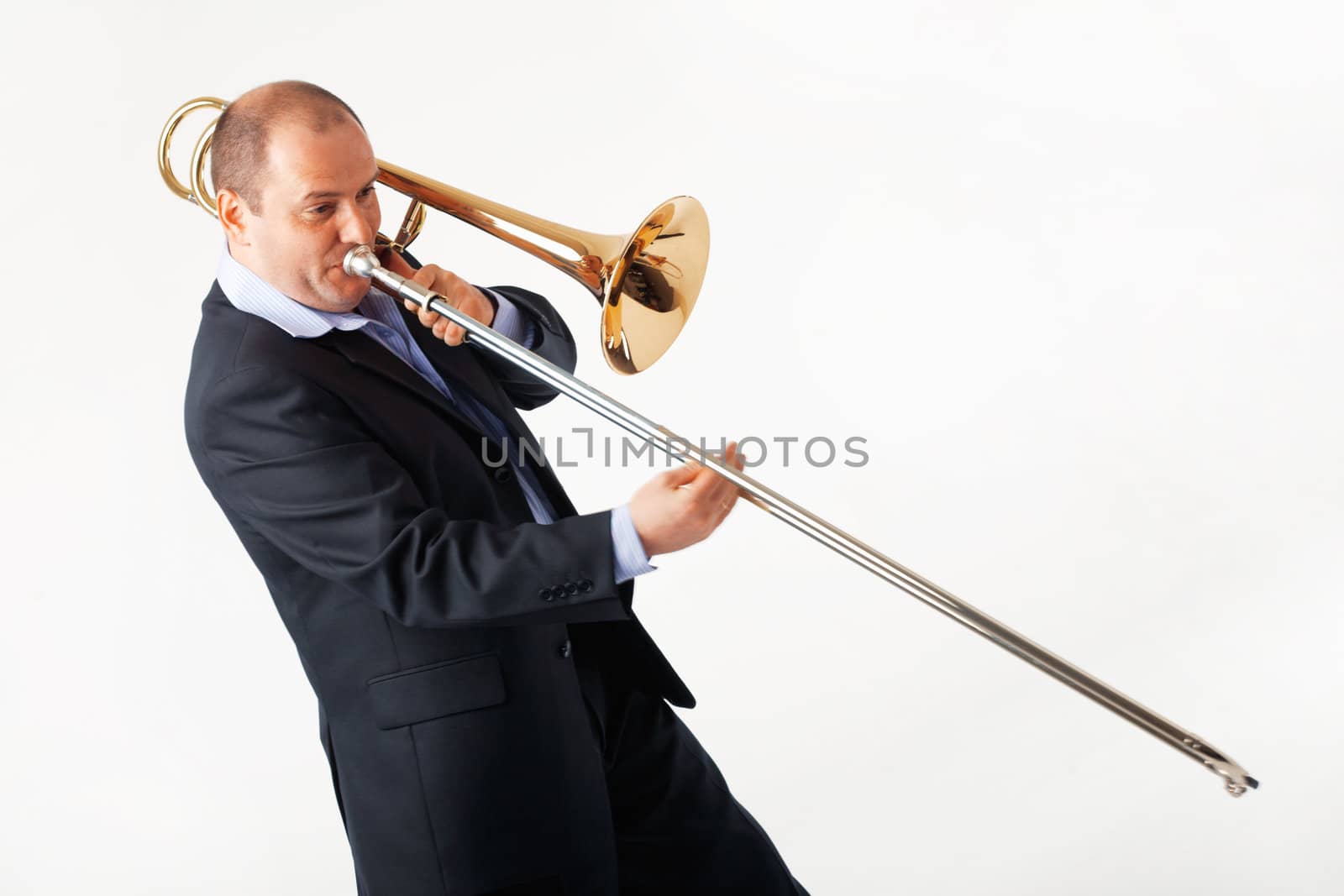 Portrait of a young man playing his trombone.