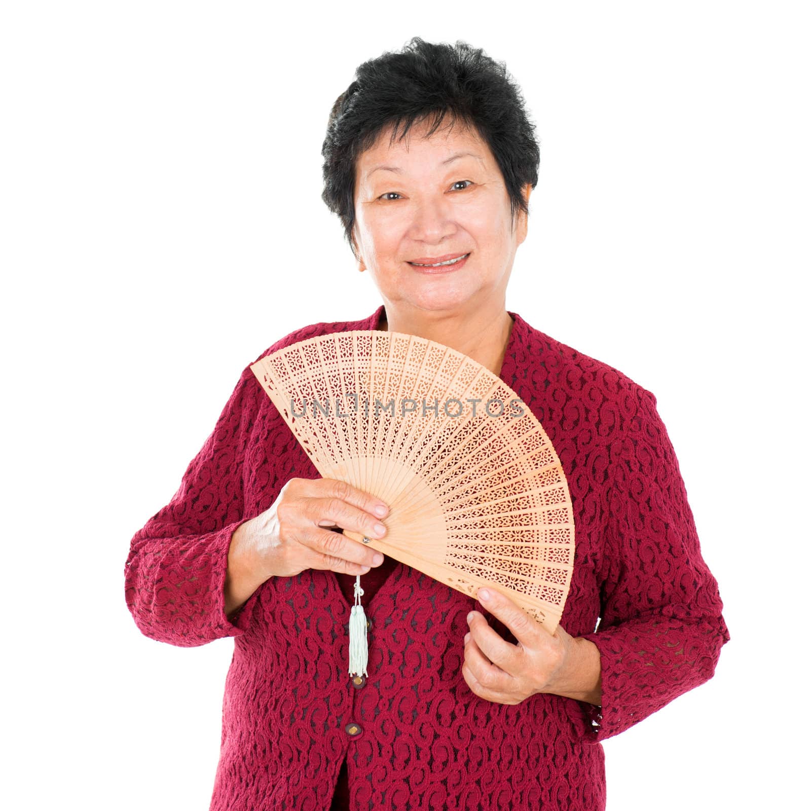 Oriental senior woman with Chinese traditional dress and Chinese Fan, standing over white background
