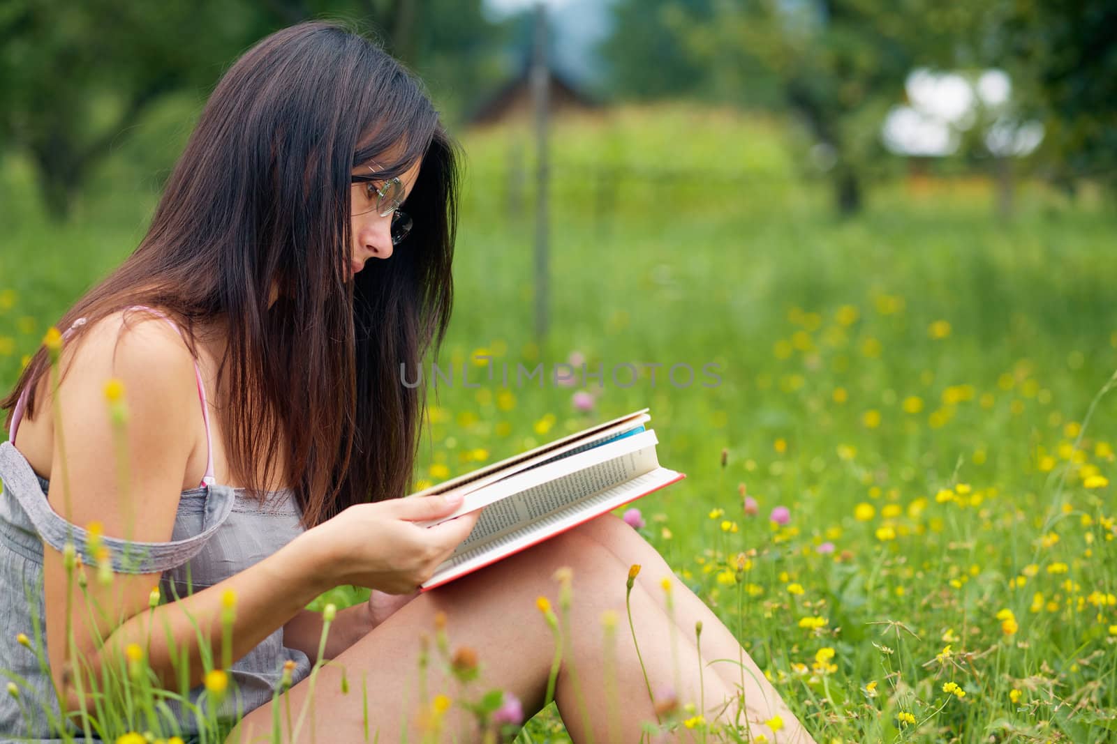 Young woman reading a book outdoors.