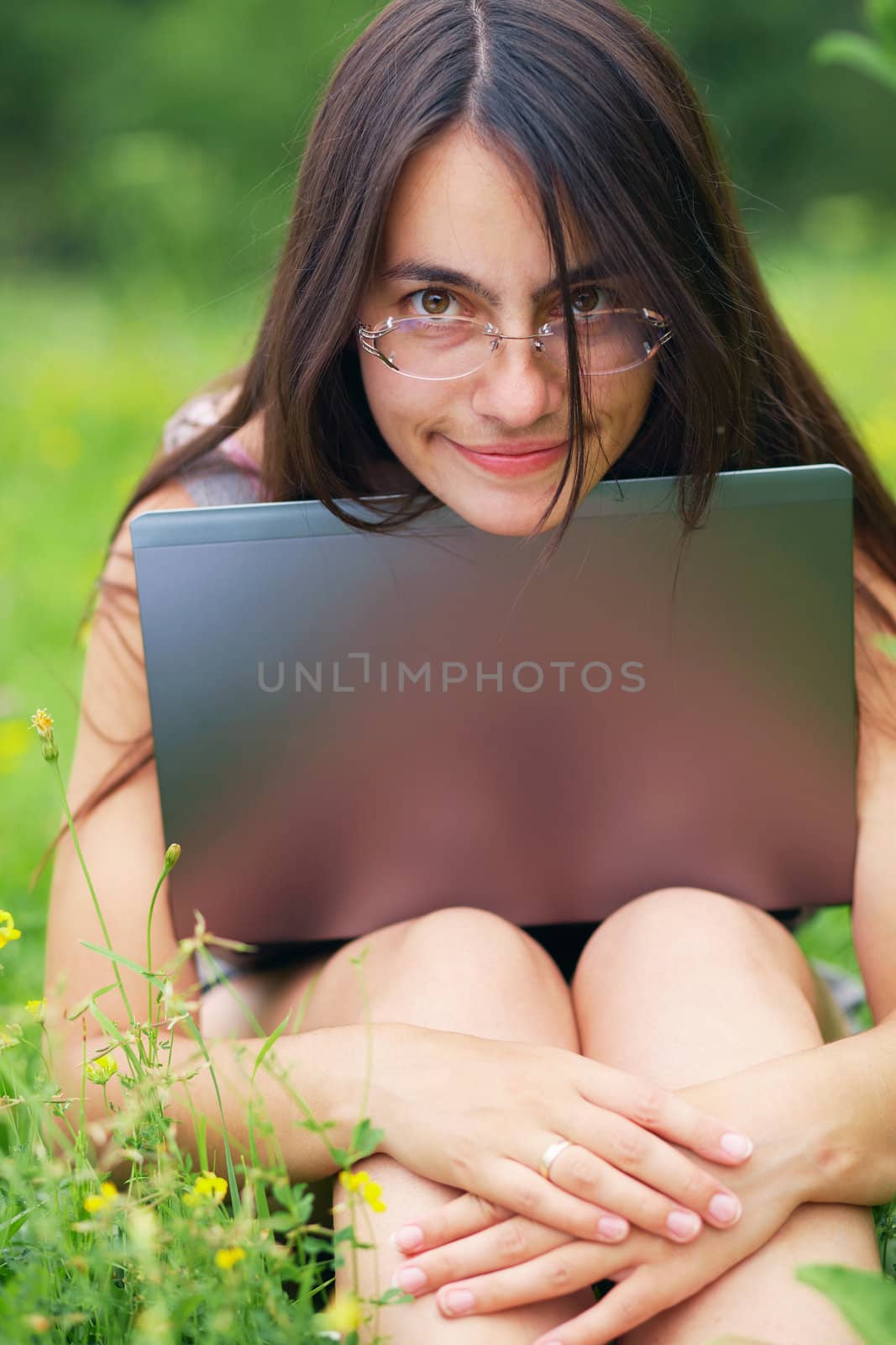Close-up portrait of a happy woman with laptop outdoors