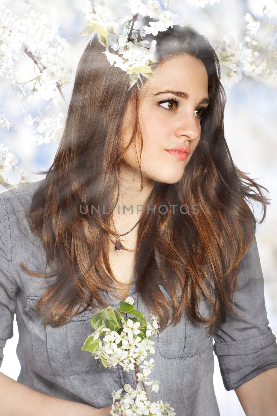 Portrait of a Beautiful Girl with Flowers from a Blooming Tree