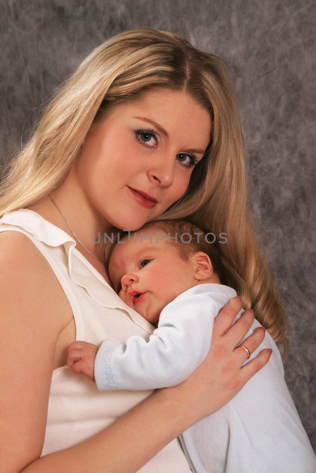 Mother with her sleeping newborn baby in home